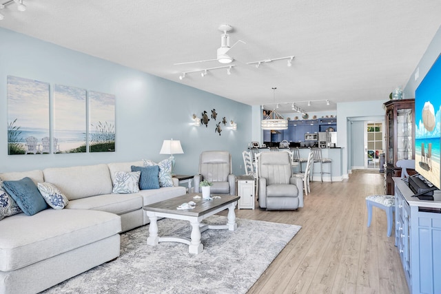 97501 Overseas Hwy Unit 113, Key Largo, FL 33037 - living room featuring track lighting, light wood-type flooring, ceiling fan, and a textured ceiling