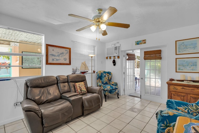 living room featuring a wall unit AC, ceiling fan, and light tile patterned floors