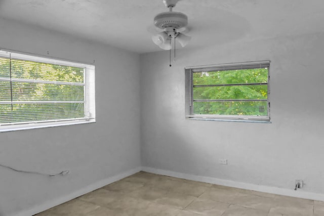 unfurnished room featuring a ceiling fan and baseboards