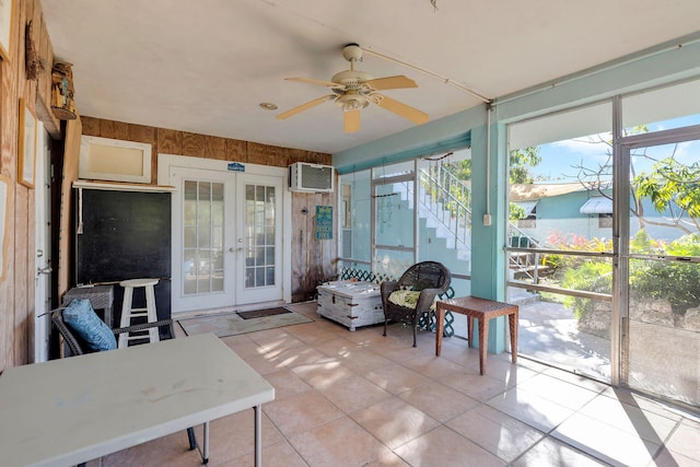 sunroom featuring french doors, a wall unit AC, and a ceiling fan