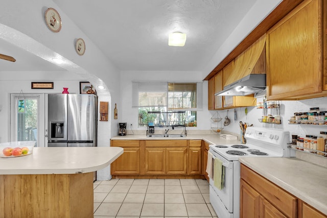 kitchen featuring under cabinet range hood, a sink, light countertops, stainless steel refrigerator with ice dispenser, and white range with electric stovetop