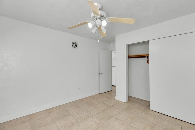 unfurnished bedroom with a ceiling fan, a closet, light tile patterned flooring, and baseboards