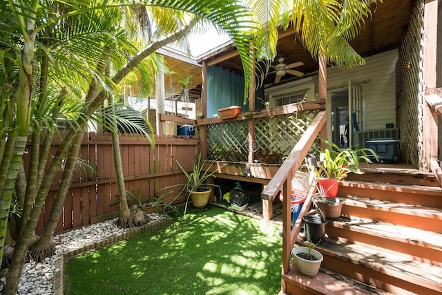 view of yard featuring fence and a ceiling fan