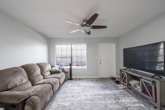 living area featuring carpet flooring, a ceiling fan, and baseboards