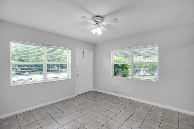 spare room featuring ceiling fan and a wealth of natural light