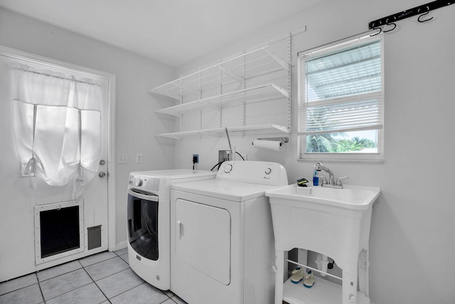 laundry area with light tile patterned flooring, sink, and washer and dryer