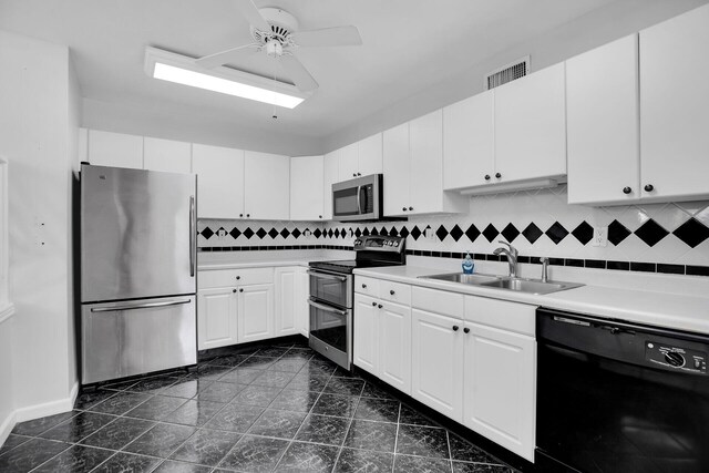 kitchen with appliances with stainless steel finishes, tasteful backsplash, white cabinetry, sink, and ceiling fan