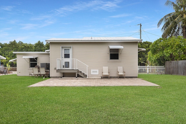 back of property with a lawn and a patio