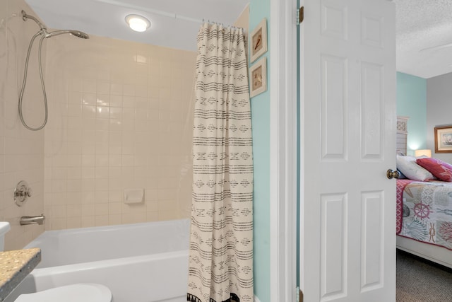 bathroom featuring shower / bathtub combination with curtain, vanity, and a textured ceiling