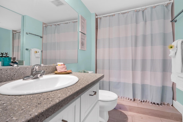 bathroom featuring vanity, toilet, and a shower with shower curtain