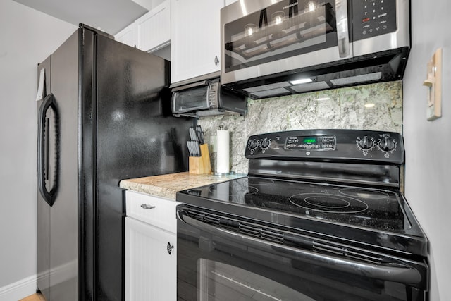 kitchen featuring white cabinetry, decorative backsplash, and black appliances