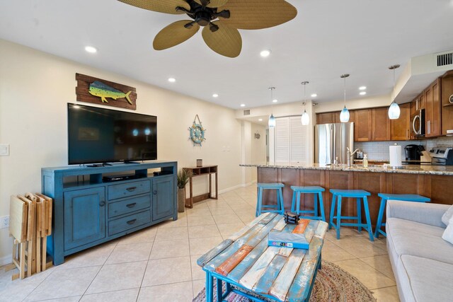 living room with light tile patterned floors, ceiling fan, baseboards, and recessed lighting