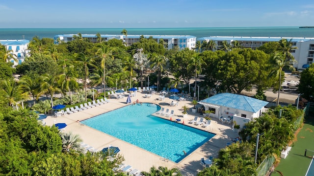 view of pool with a water view and a patio