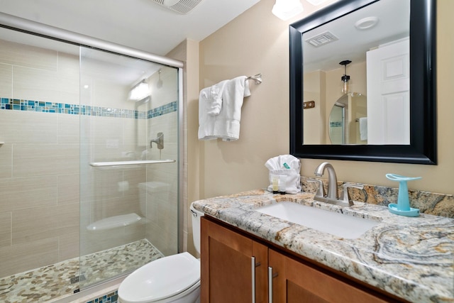 full bathroom with a stall shower, visible vents, vanity, and toilet