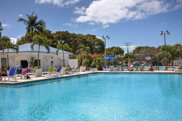 pool with a patio and fence