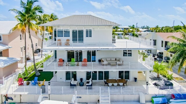 rear view of house featuring a balcony, an outdoor living space, and a patio area