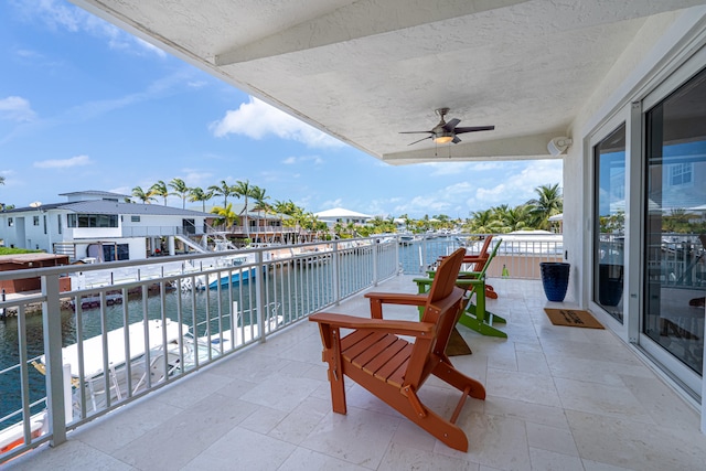 balcony with a water view and ceiling fan