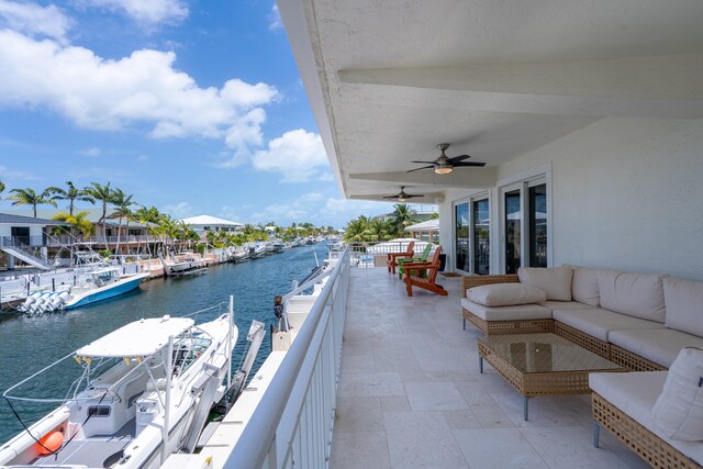 view of patio featuring an outdoor hangout area, a balcony, ceiling fan, and a water view