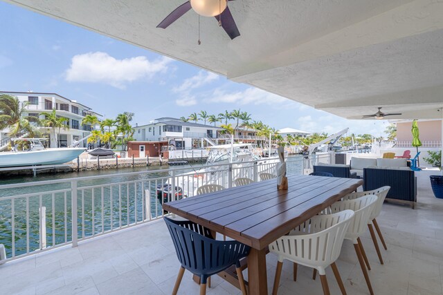 view of patio with a water view, outdoor lounge area, a dock, and ceiling fan