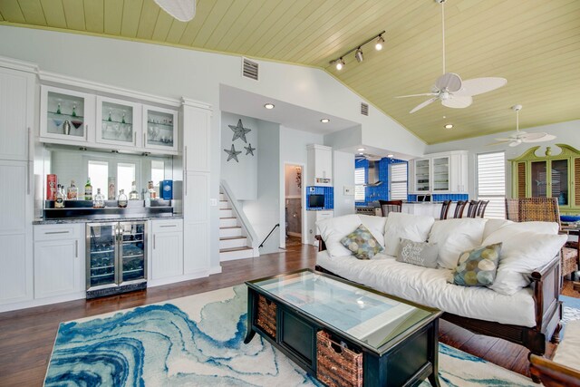 living room with wood ceiling, rail lighting, dark hardwood / wood-style flooring, beverage cooler, and indoor bar