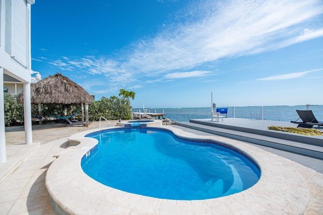 view of swimming pool featuring a gazebo, a water view, an in ground hot tub, and a patio area