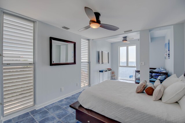 bedroom featuring a water view and ceiling fan