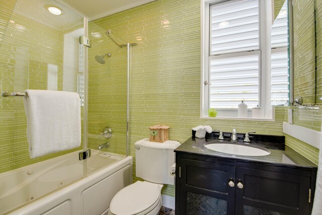 full bathroom featuring tiled shower / bath combo, vanity, tile walls, and toilet