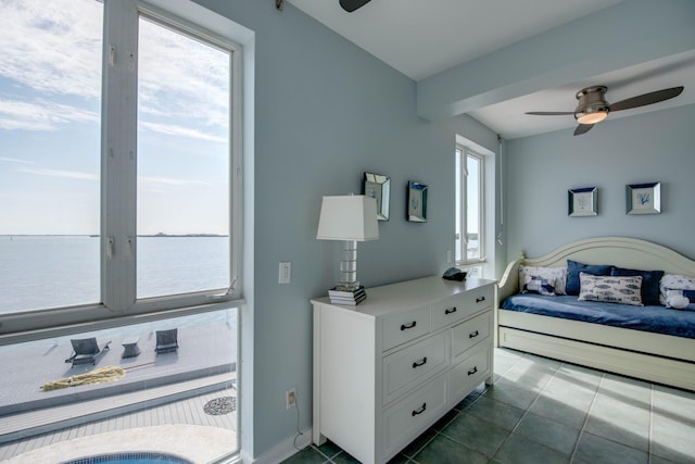 bedroom with tile patterned flooring, a water view, and ceiling fan