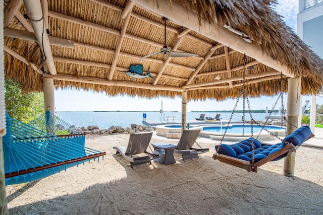 view of patio featuring a gazebo, a water view, a swimming pool with hot tub, and ceiling fan