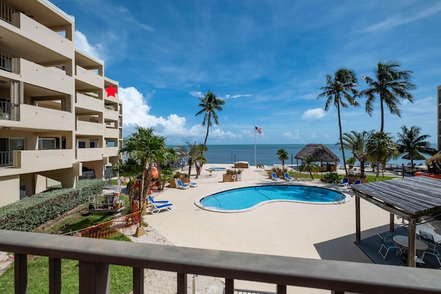 view of pool featuring a water view and a patio area