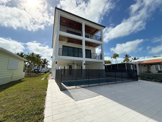 rear view of property with a swimming pool, a yard, ceiling fan, and a patio area