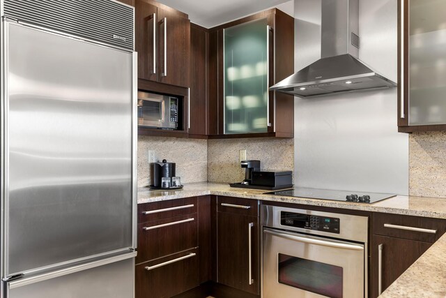 3841 N Roosevelt Blvd Unit 315, Key West, FL 33040 - kitchen featuring glass insert cabinets, wall chimney range hood, dark brown cabinets, stainless steel appliances, and decorative backsplash