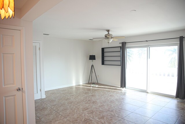 empty room featuring ceiling fan and light tile patterned floors