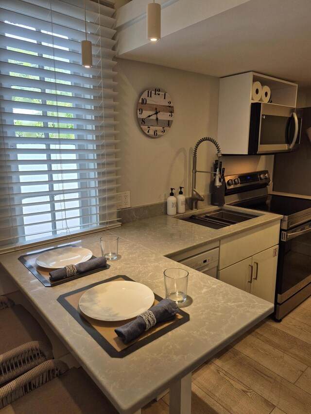 1220 Newton St Unit 1, Key West, FL 33040 - kitchen featuring appliances with stainless steel finishes, light wood finished floors, and white cabinets