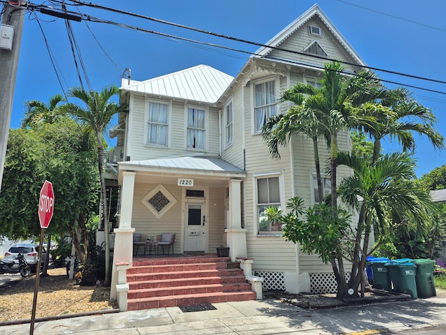 1220 Newton St Unit 1, Key West, FL 33040 - view of front facade with a metal roof, a porch, a standing seam roof, and a chimney