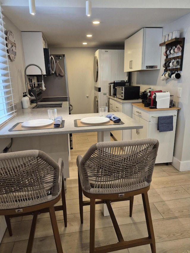 1220 Newton St Unit 1, Key West, FL 33040 - kitchen featuring light wood finished floors, white cabinets, light countertops, stainless steel microwave, and recessed lighting
