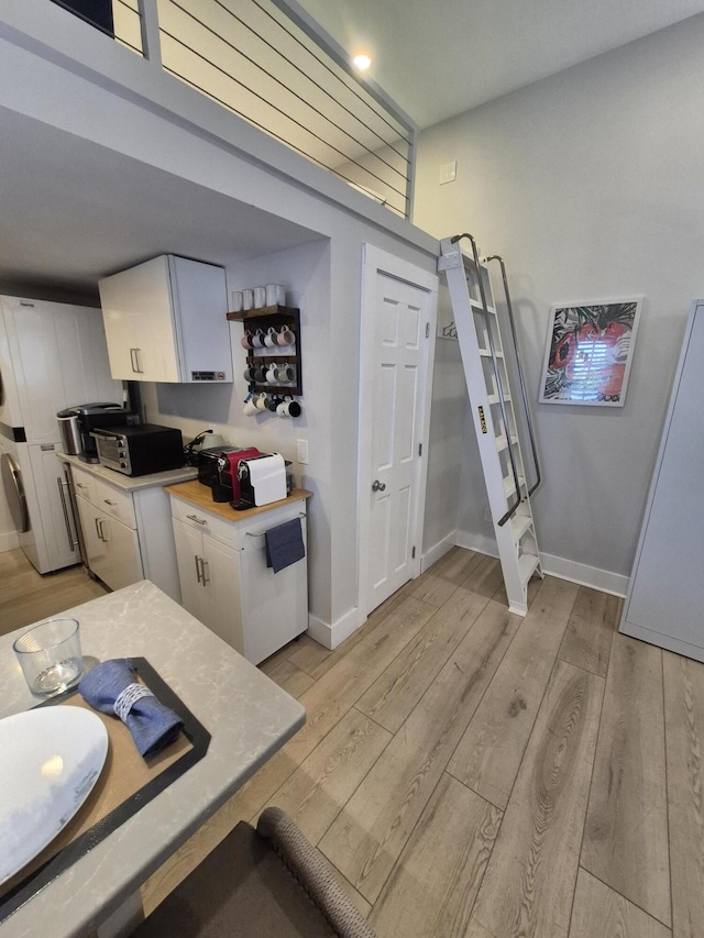 1220 Newton St Unit 1, Key West, FL 33040 - kitchen with light countertops, light wood-style flooring, and white cabinets