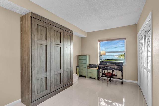 home office featuring baseboards and a textured ceiling