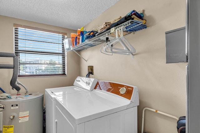 laundry room featuring washing machine and dryer, laundry area, electric water heater, and a textured ceiling