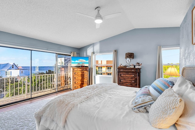 bedroom featuring access to exterior, multiple windows, vaulted ceiling, and a ceiling fan