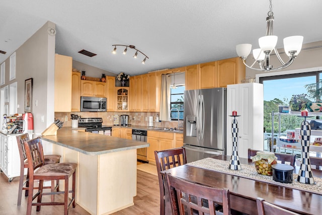 kitchen featuring a wealth of natural light, visible vents, backsplash, appliances with stainless steel finishes, and a peninsula