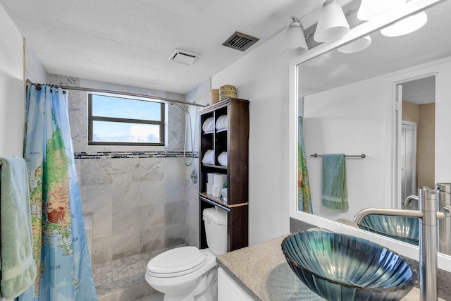 full bath with visible vents, a tile shower, vanity, and toilet