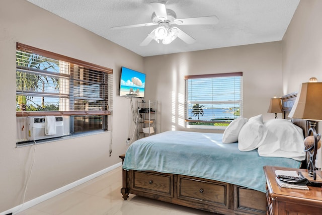 bedroom featuring ceiling fan, baseboards, and a textured ceiling