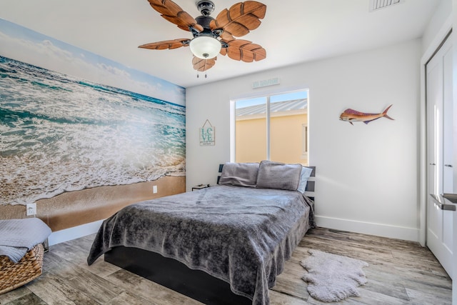 bedroom with ceiling fan, light hardwood / wood-style floors, and a closet