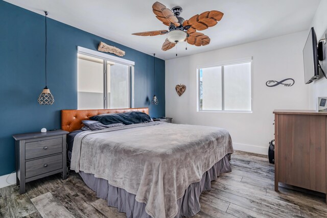 bedroom with dark hardwood / wood-style floors and ceiling fan