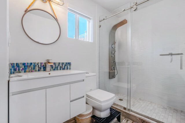 bathroom featuring vanity, toilet, and an enclosed shower