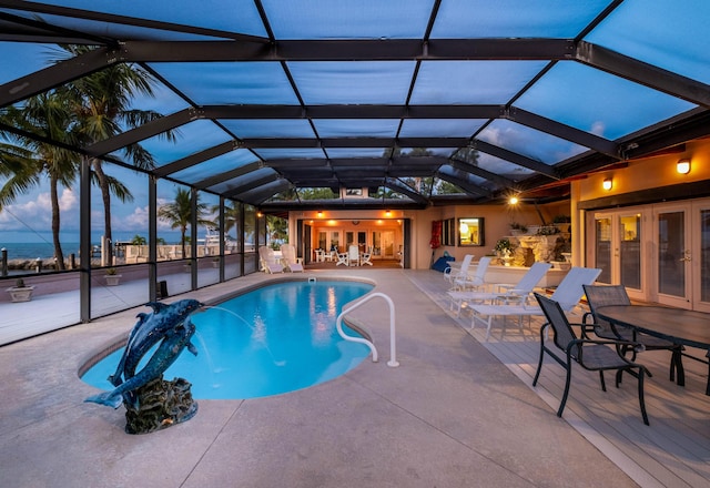 pool at dusk featuring french doors, a patio area, and an outdoor pool