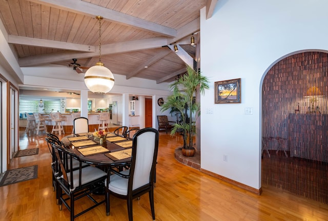 dining room featuring lofted ceiling with beams, light wood-style floors, a ceiling fan, wood ceiling, and baseboards