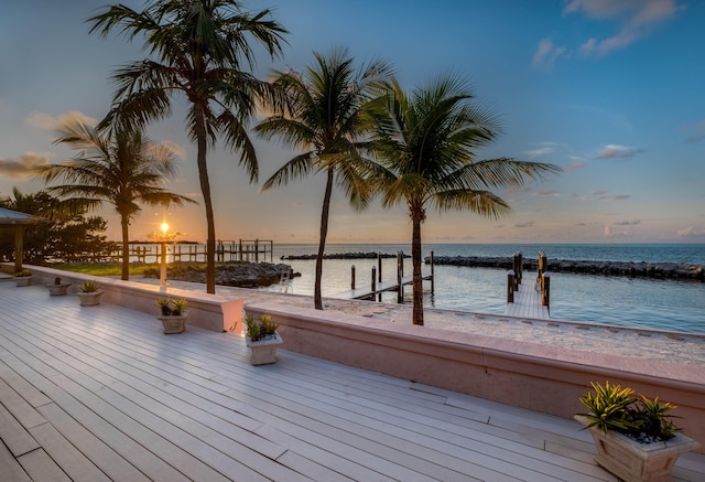 wooden terrace featuring a dock and a water view