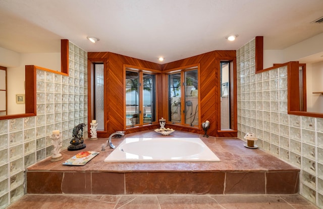 bathroom featuring backsplash and a bath